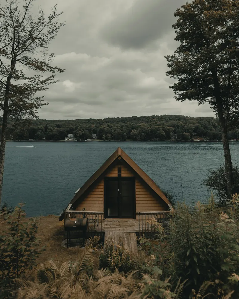 Chalet en bois au bord d'un lac, gîte photographié en Bretagne