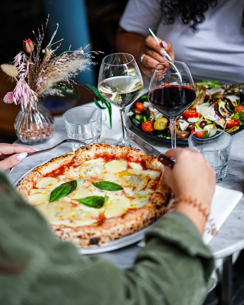 Table partagée avec pizza et verres de vin, restaurant à Paimpol