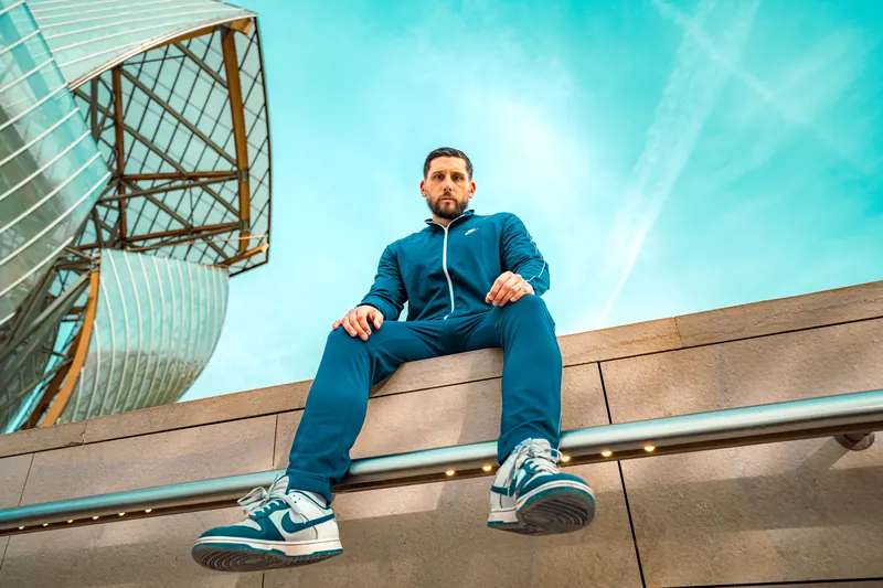 Modèle assise sur une architecture contemporaine, campagne pour une marque de sneakers